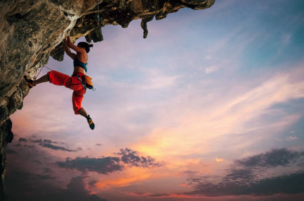 岩の上に登る女性 - overhanging ストックフォトと画像