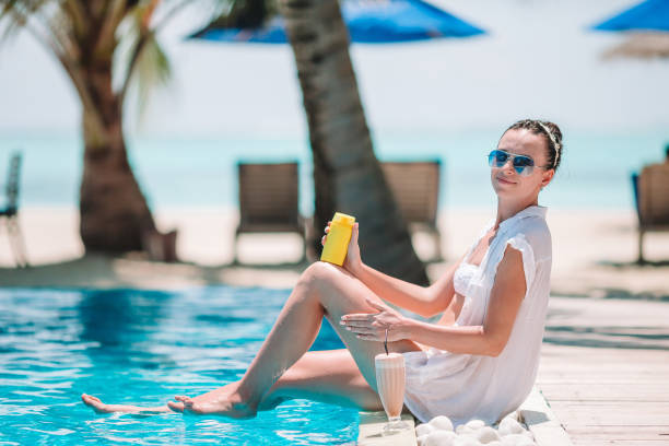 istock Young woman applying sun cream during beach vacation 1153410681