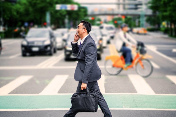 istock Entrepreneur answering phone while crossing road 1153410974