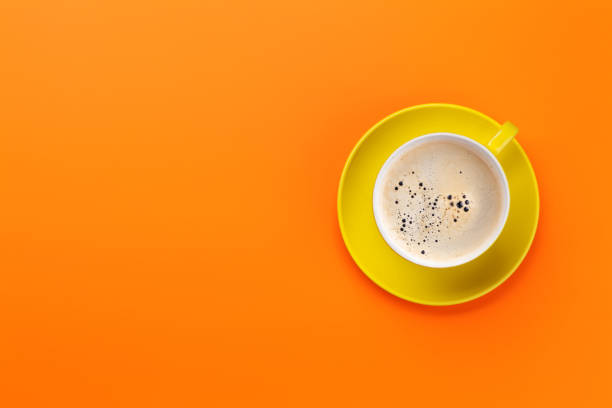 istock Yellow coffee cup over orange background 1153413206
