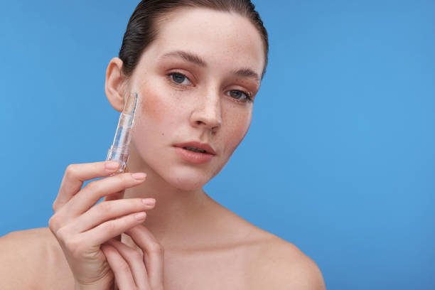 istock Young tender freckled lady holding lip balm 1153413277