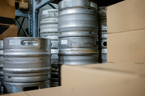 Range of stacked beer casks of kegs in warehouse