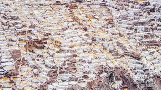 Photo of Detail of the salt terraces in the salt pans of Maras, salineras de Maras near Cusco in Peru, salt mines made by man