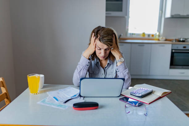 istock Worried Woman doing Paperwork 1153417400