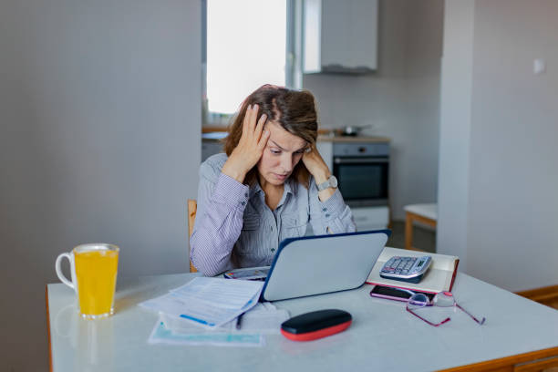 istock Worried Woman doing Paperwork 1153417408