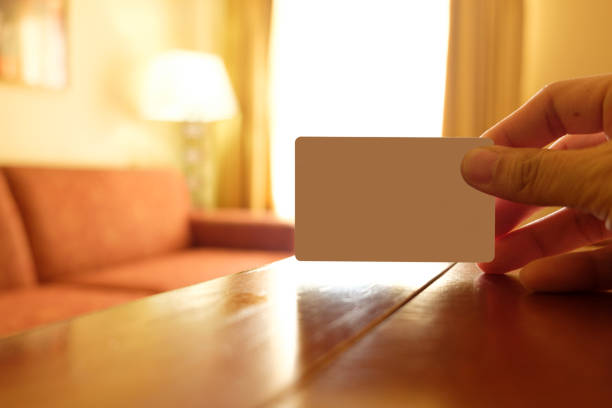 Hand hold an empty white card in a hotel room