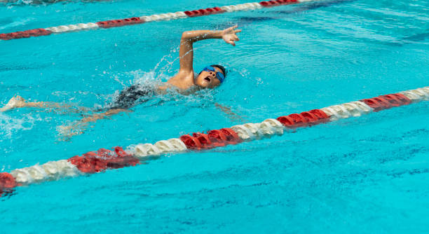 istock Young chinese boy with goggles swims freestyle 1153420417