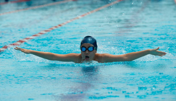 istock Young chinese boy with goggles swims butterfly 1153420423