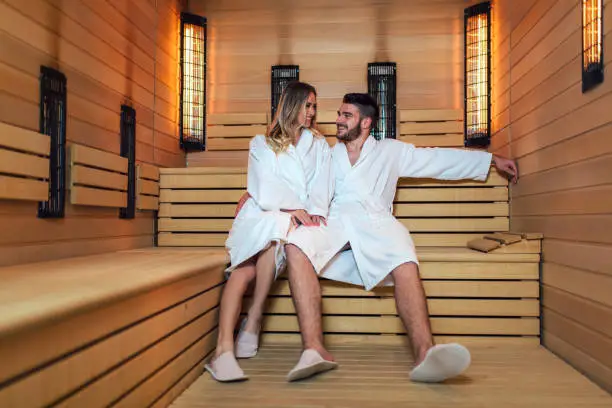 Photo of Healthy beautiful couple relaxing in sauna during wellness weekend