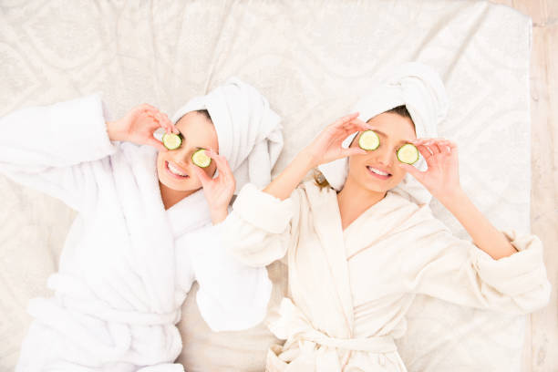 istock Two girls  with cucumbers on eyes  lying on the bed 1153422552