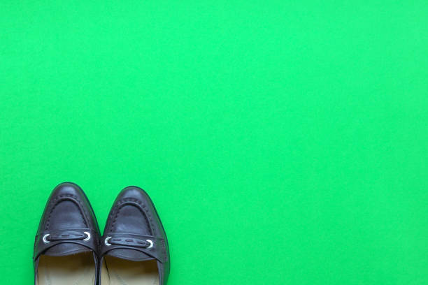 istock Women shoes on green background 1153423707