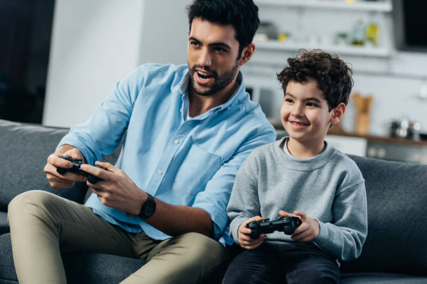 istock happy latin father and son playing video game at home 1153423832