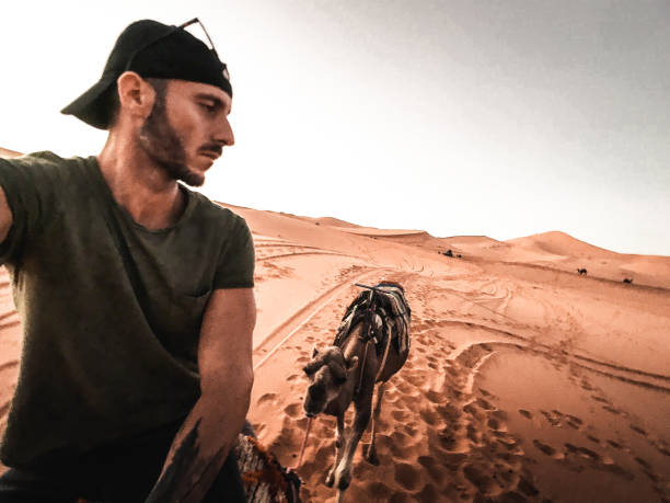 istock man take a selfie on a camel 1153424326