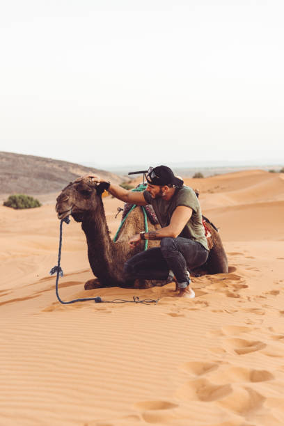istock man in the desert with camel 1153425273