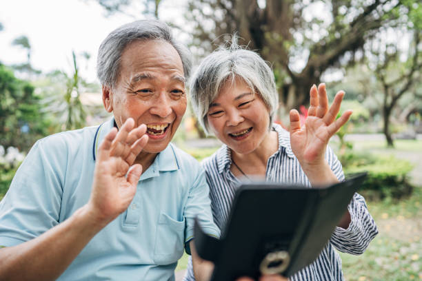 istock Senior couple using smart phone in park 1153425625