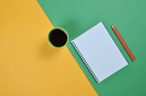 istock Top view flat lay picture with blank notepad page, coffee cup, pencil and different accessories on colored surface 1153426017
