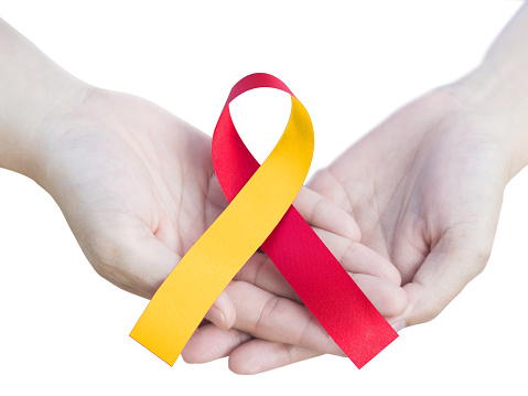Concepto del día mundial de la hepatitis. Conciencia de cinta roja y amarilla a mano aislada sobre fondo blanco para contra hepatitis C y co-infección por VIH/VHC con trayectoria de recorte. photo