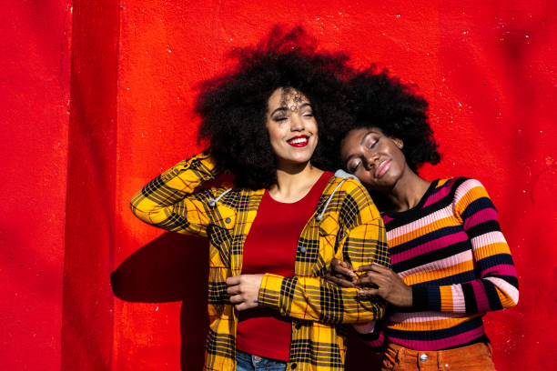 istock Happy african women standing on red background 1153427562