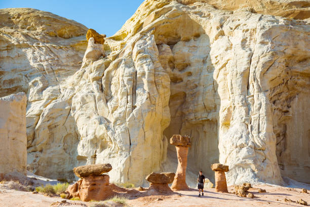 Man with Hoodoos A man walks among a garden of toadstool hoodoos in Escalante National Monument. grand staircase escalante national monument stock pictures, royalty-free photos & images