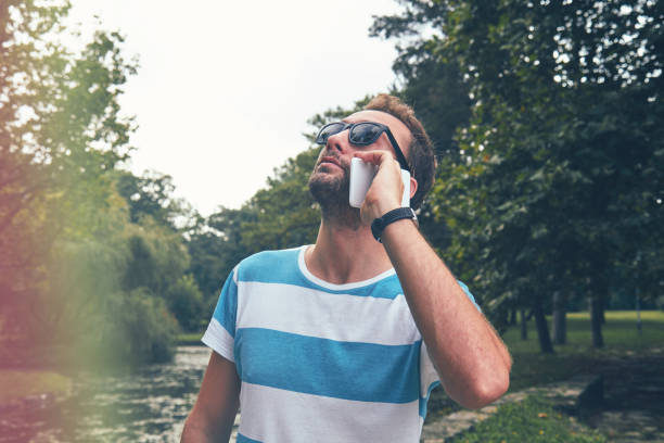 Trendy man using cellphone outdoors.