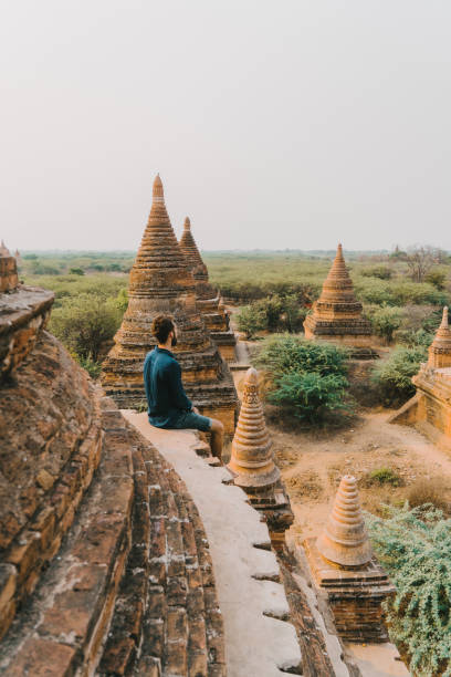 man looking at scenic  view of bagan heritage site from above - burmese culture myanmar pagoda dusk imagens e fotografias de stock