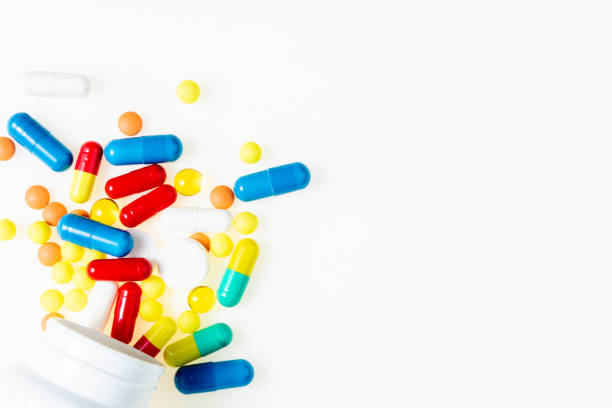 istock Pill bottle with assorted pharmaceutical medicine pills, tablets, capsules on white background top view. Medical pharmacy background 1153430667