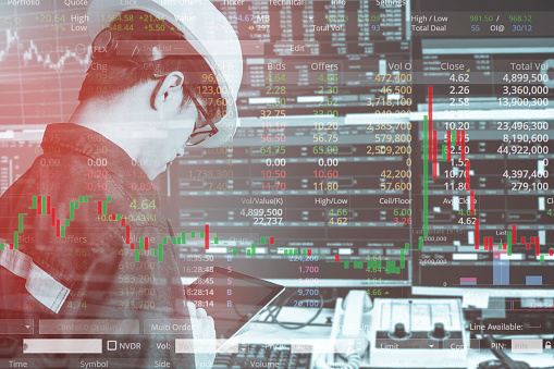 Double exposure of business man or engineer using tablet with stock trading room and stock trading chart background for investment business concept.
