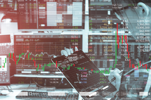 Double exposure of business woman using tablet with stock trading room and stock trading chart background for investment business concept.