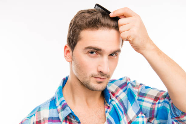 istock Handsome young man combing his hair 1153434265