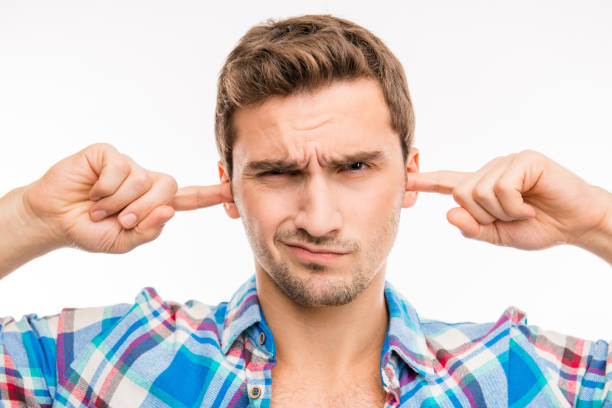 istock Young man covering his ears ignoring noise 1153435204