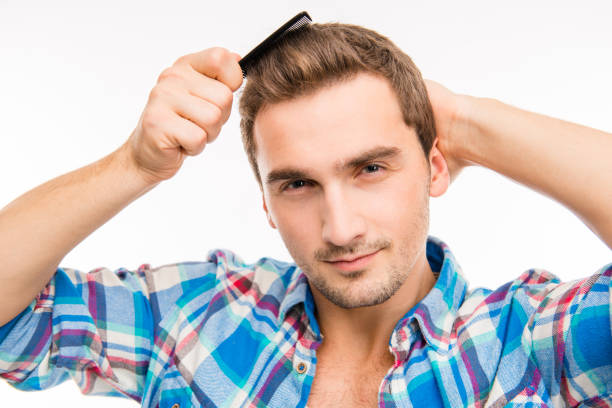 istock Handsome cheeky young man combing his hair 1153435221
