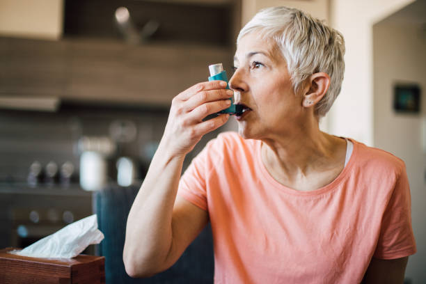 donna che usa l'inalatore per l'asma - blue medicine narcotic healthy lifestyle foto e immagini stock