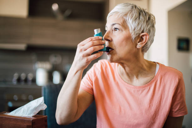 mulher que usa o inalador da asma - asthma inhaler - fotografias e filmes do acervo