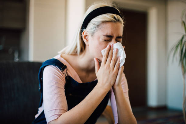 istock Ill girl blowing her nose 1153440436
