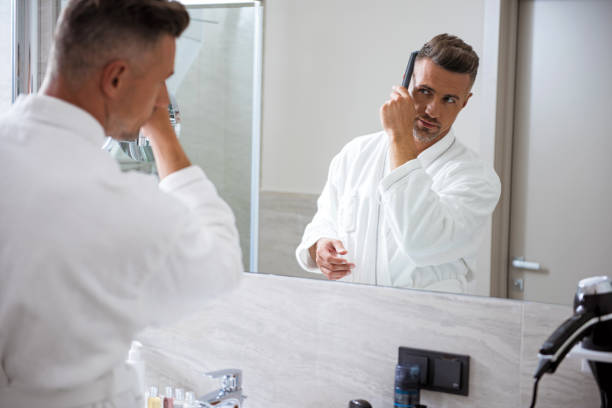 istock Attractive young man changing his hairstyle in front of the mirror 1153440549