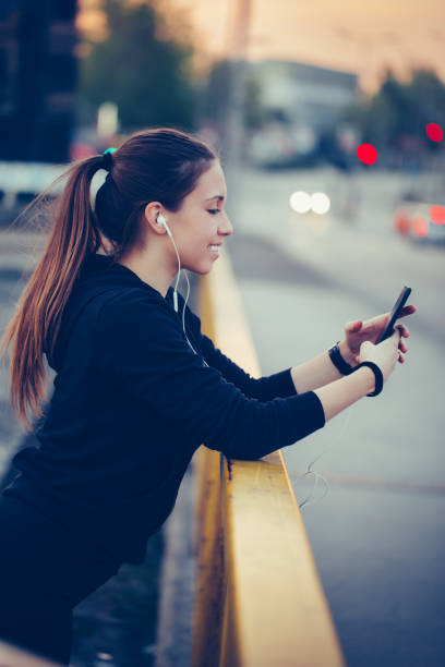 istock Sporty girl using a cellphone while working out on the bridge 1153440757