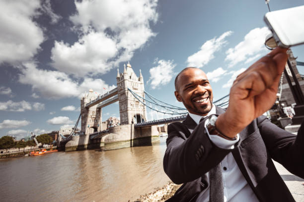 istock businessman take a selfie on tower bridge london 1153443195