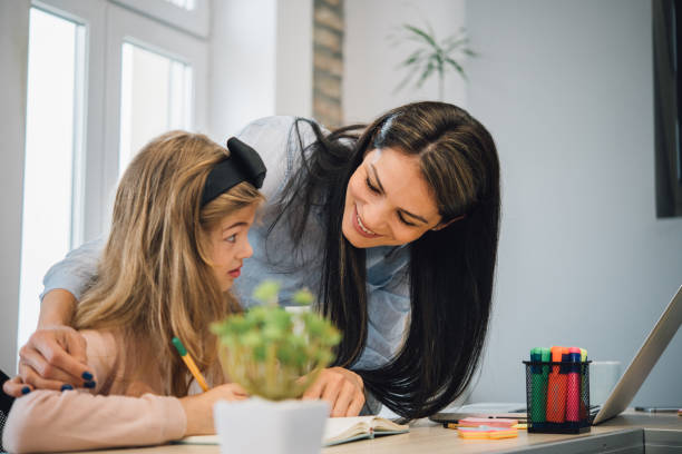 istock Woman looking at her daughter writing 1153443381