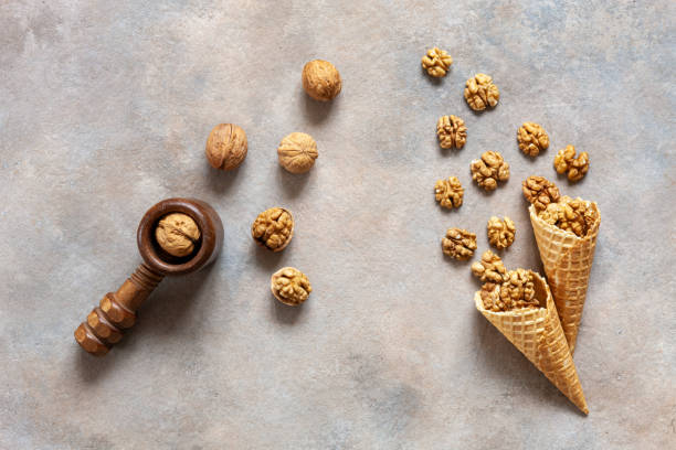 istock Walnuts in waffle cone and wooden vintage nutcracker. Close-up, top view, flat lay on concrete gray background. 1153446771