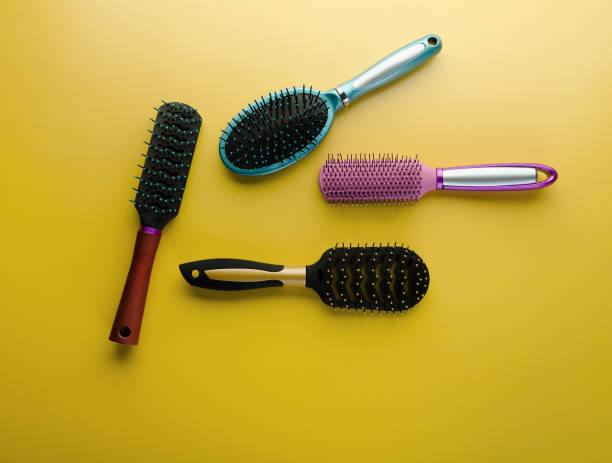 istock Various colored brushs and combs for hair on yellow background. 1153447106