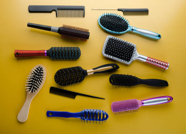 istock Various colored brushs and combs for hair on yellow background. 1153447137