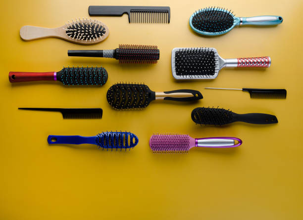 istock Various colored brushs and combs for hair on yellow background. 1153447148