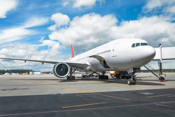 istock Passenger aircraft with boarding stairs, waiting for boarding passengers and baggage before the flight, summer airport trip. 1153447345