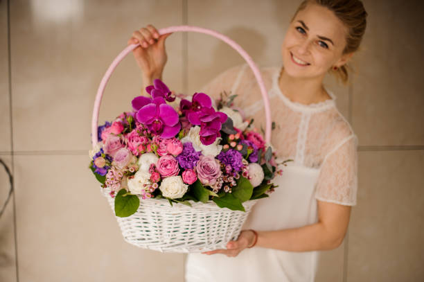 istock Basket with different flowers in girl's hands 1153448285