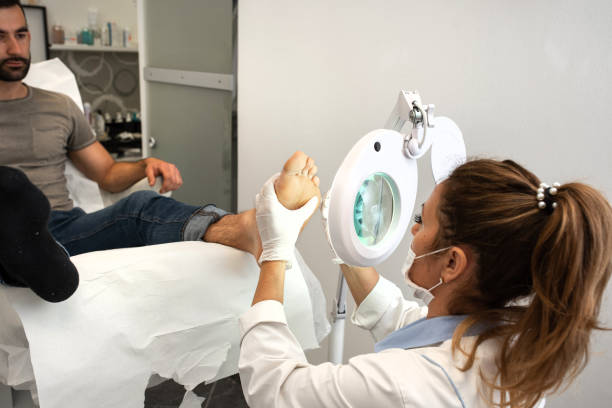 Professional Pedicure Using Electric Machine to Remove Foot Calluses stock photo