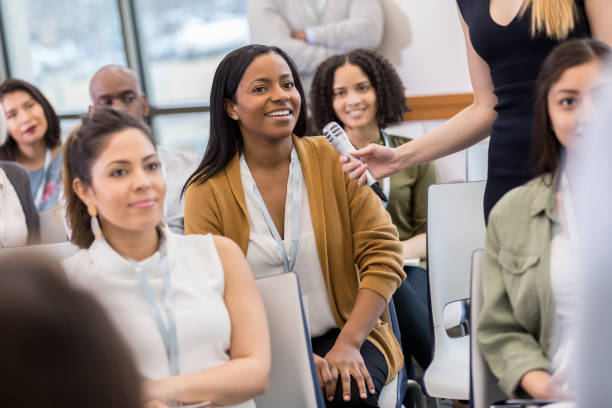 istock Confident, attractive woman asks expo speaker a question 1153450869