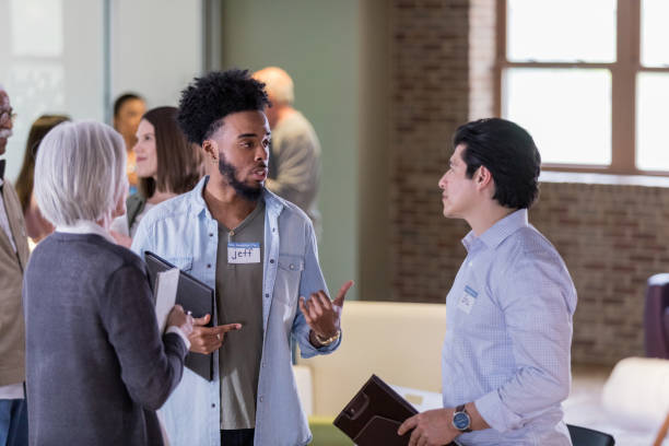 istock Young man talks with neighbors during meet and greet event 1153451084