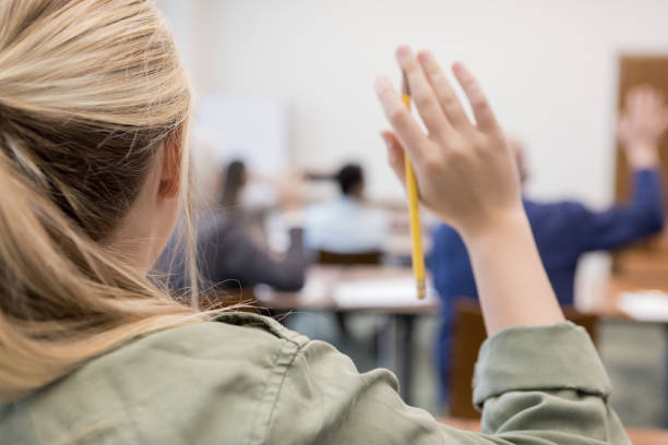 Unrecognizable Caucasian teen raises hand in class An unrecognizable Caucasian teen boldly raised her hand in an adult continuing education class held at the community college. teenage high school girl raising hand during class stock pictures, royalty-free photos & images