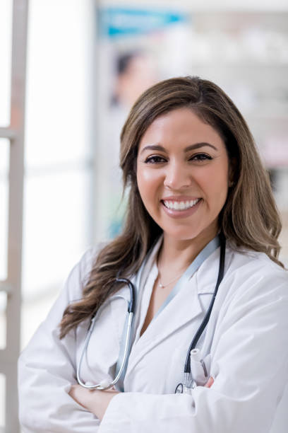 istock Hispanic nurse with stethoscope smiles for camera 1153451710