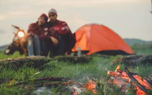 Blurred background. Blurred couples are jumping happy on vacation in countryside , Couple camping, Great warm evening, camping concept.